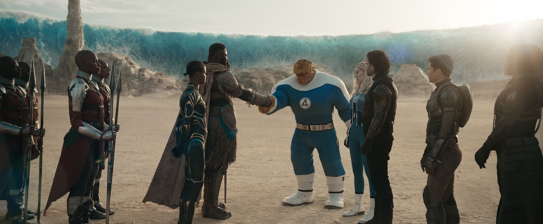 Krijgers van Wakanda schudden The Thing van de Fantastic Four de hand in een woestijnlandschap, met een reusachtige bevroren golf op de achtergrond, officieel persbeeld uit Avengers: Doomsday