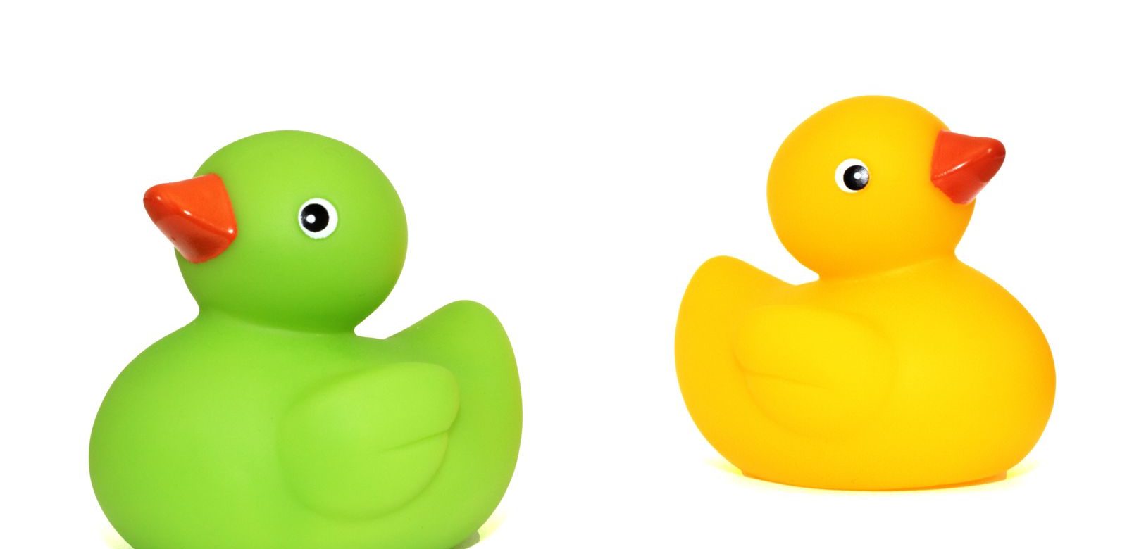 Groene en gele rubberen eend speelgoed geïsoleerd op een witte achtergrond