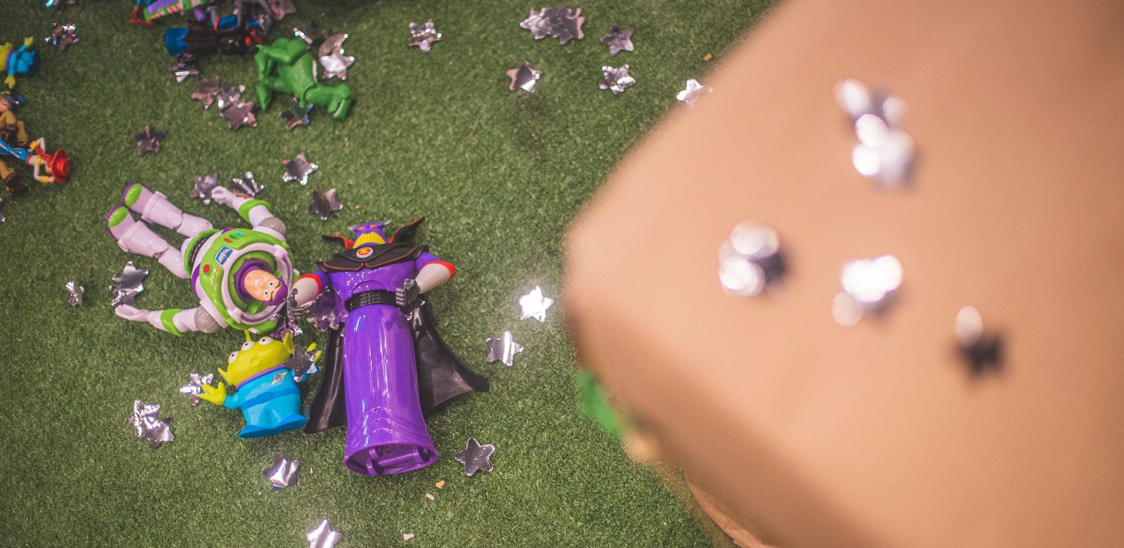 Buzz Lightyear en Zurg speelgoedfiguren op kunstgras omringd door stervormige decoraties