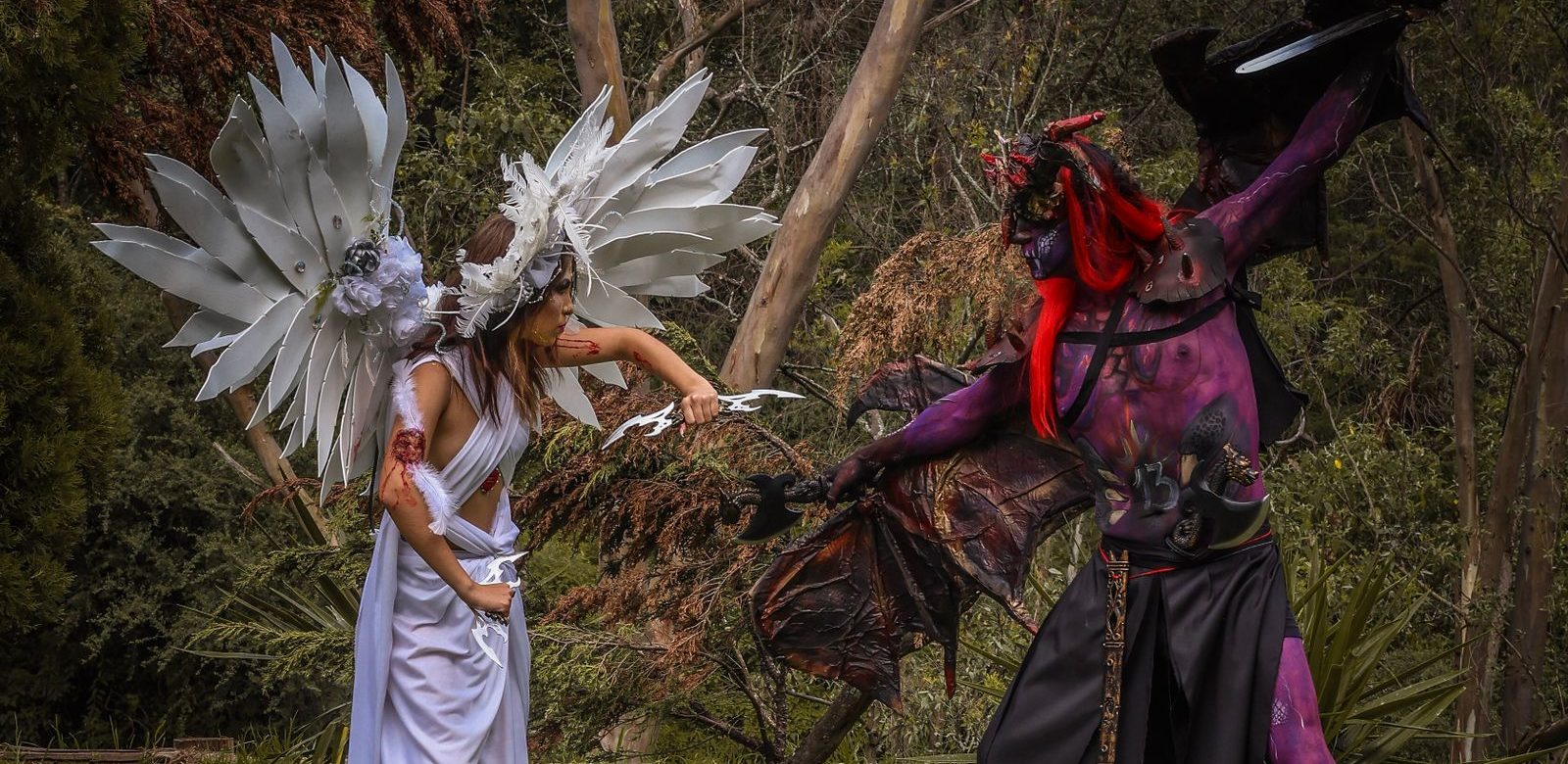 Cosplayers in engel- en demonkostuums tegenover elkaar