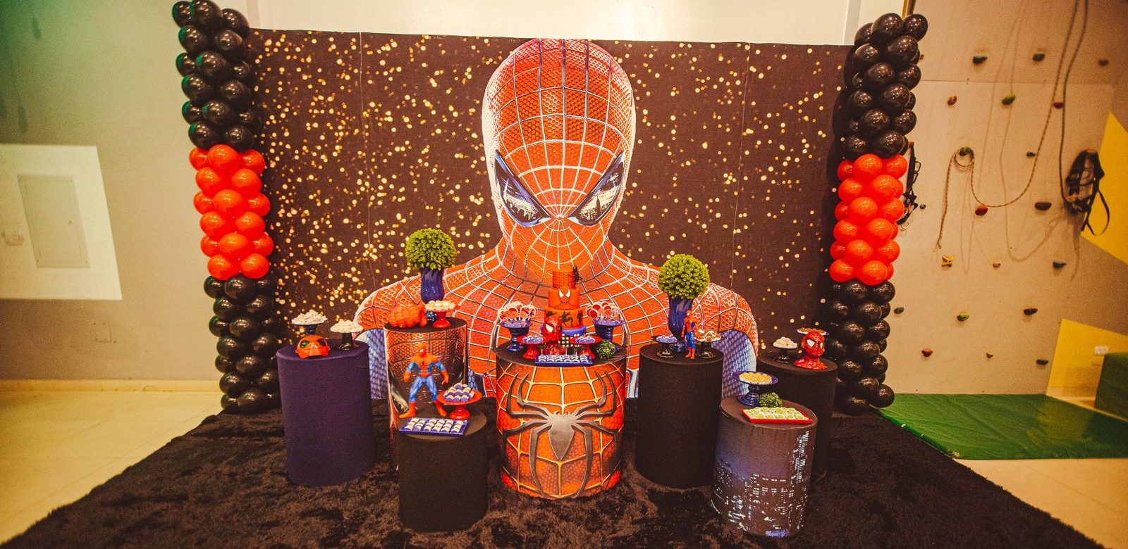 Een kleurrijke Spider-Man themaverjaardagsdecoratie met ballonnen en figuurtjes