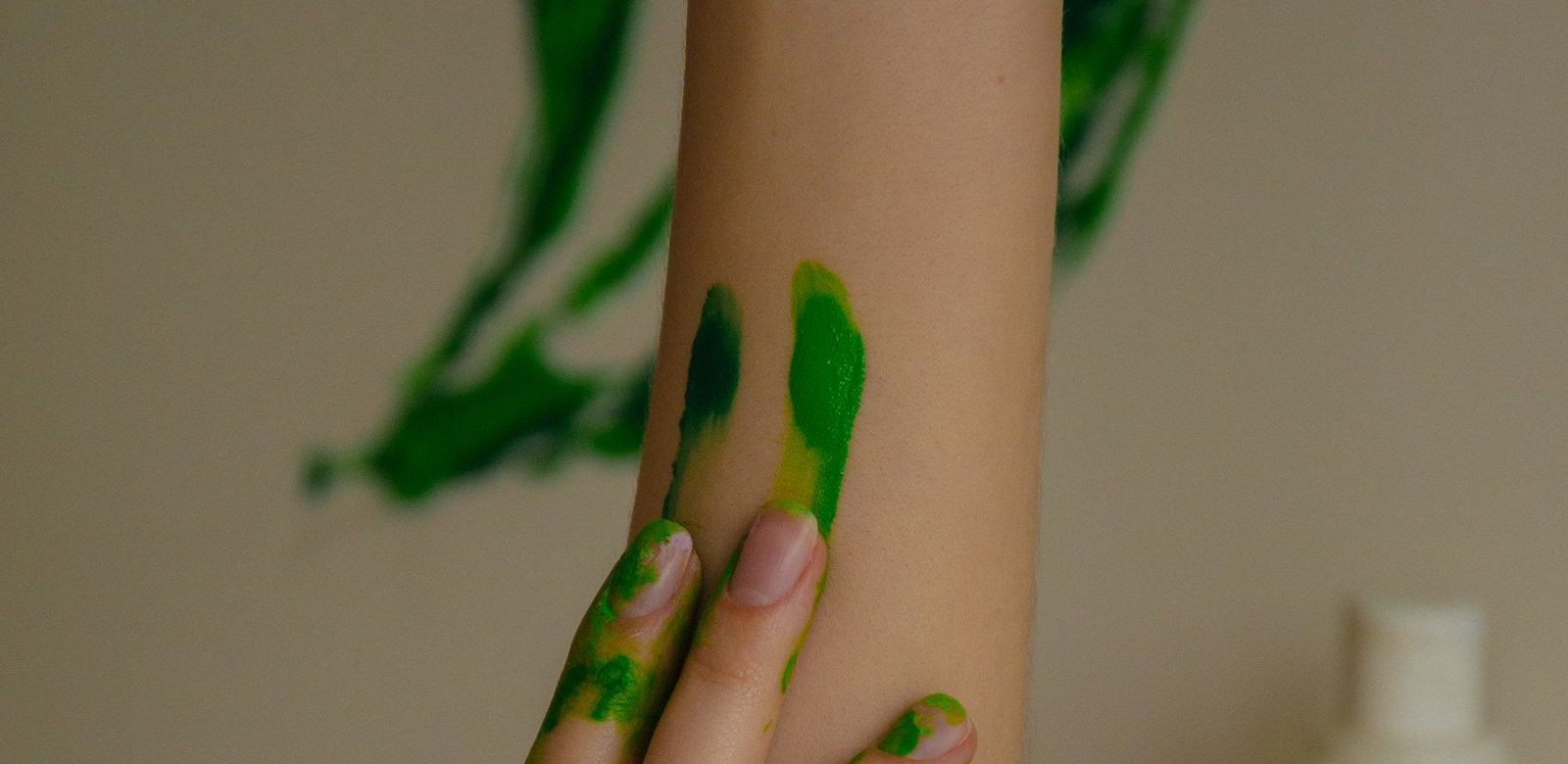 Een arm wordt met groene verf beschilderd