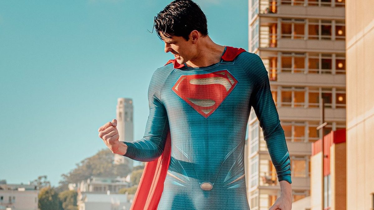 Een Superman-figuur klimt langs een gebouw bij neonlicht